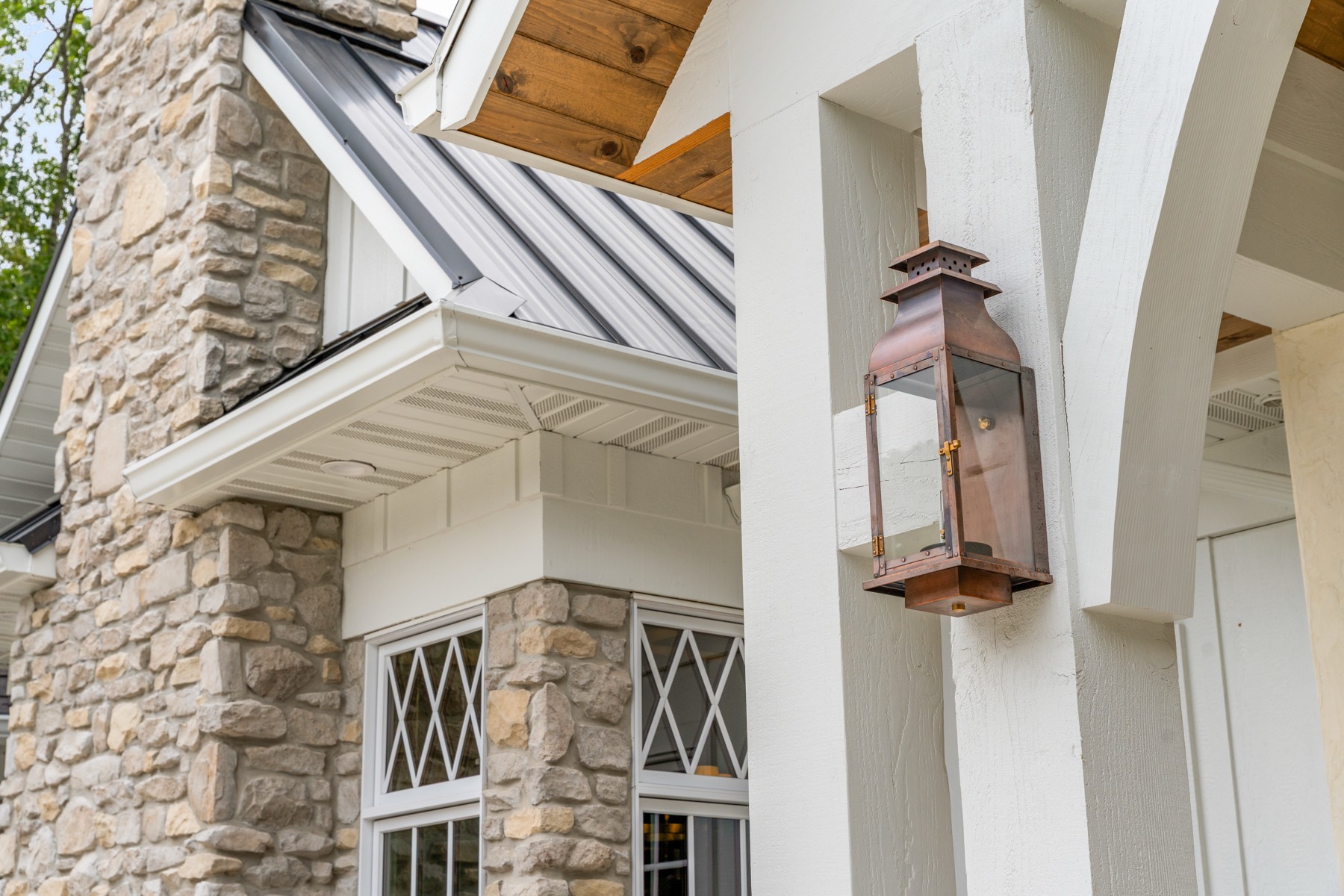 Stone chimney and copper lantern on a craftsman home