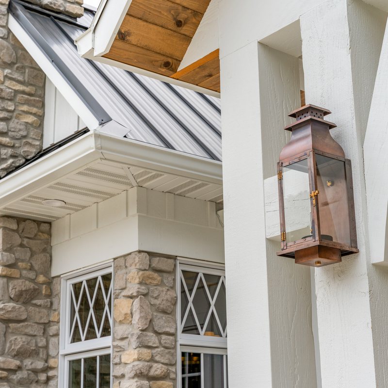 Stone chimney and a copper lantern at the front of the house