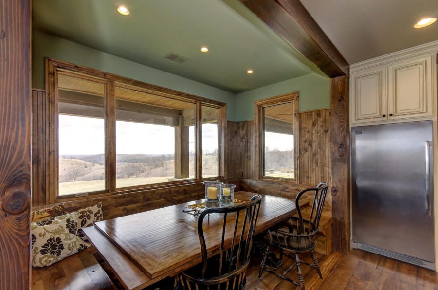 A dining room with a wall of windows over the valley