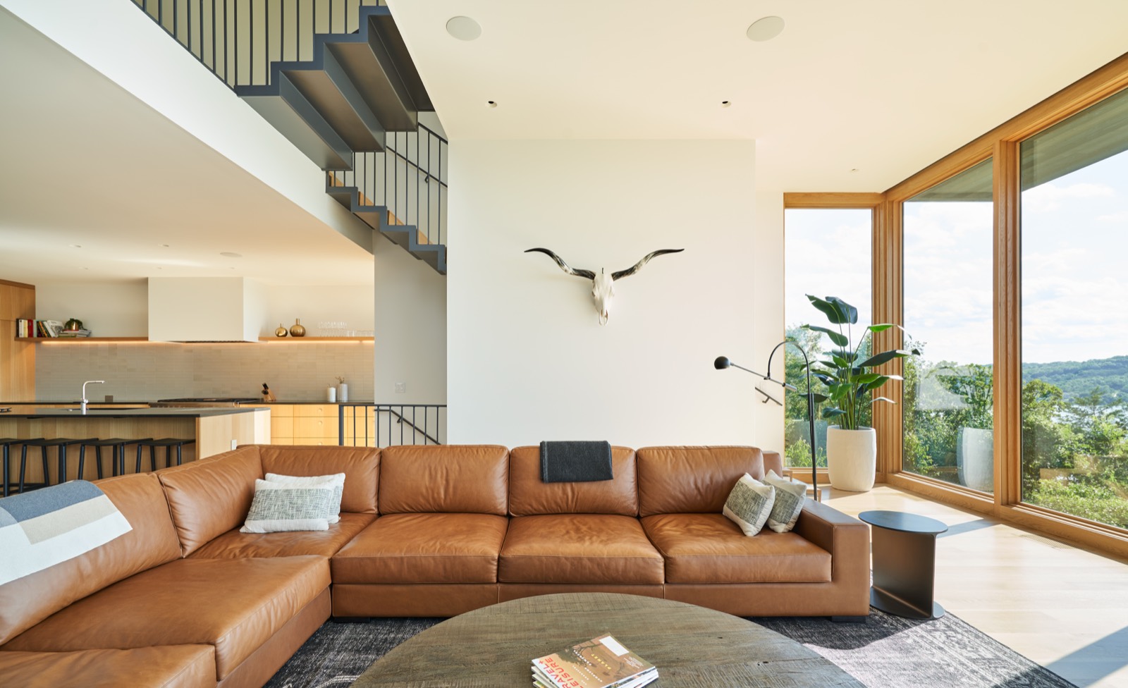 Living room with a leather sectional and windows onto the lake