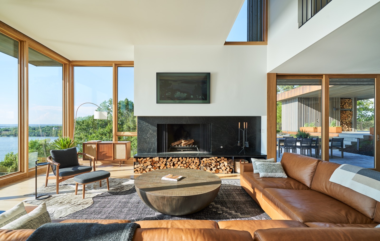 Living room with a fireplace and a wall of glass facing the water